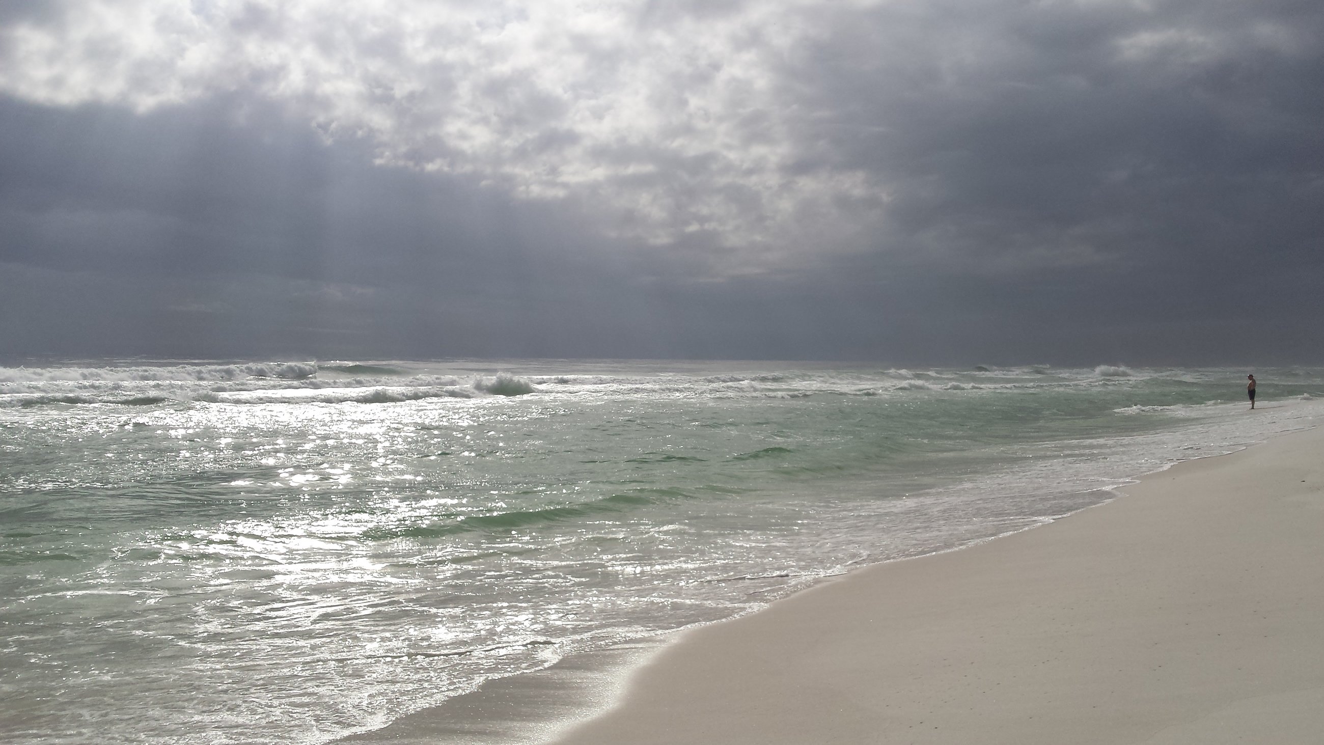 beach and calm waters with heavy cloud cover