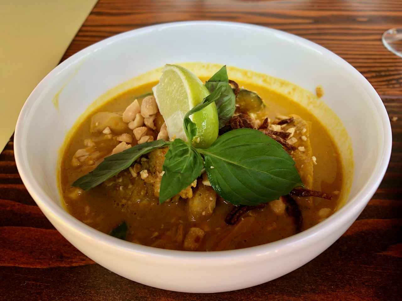 Thai yellow curry: a mild yellow curry broth with chicken, Kabota squash, rice noodles, fried shallots and peanuts