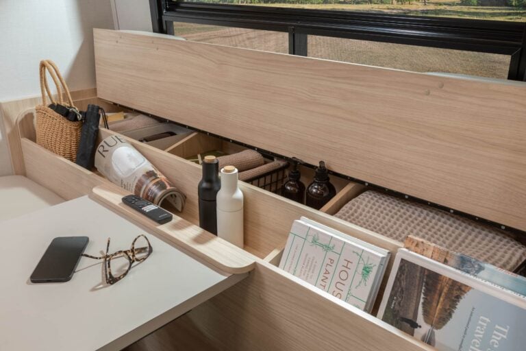 Unity Corner Bed shown with White Oak cabinetry, Concrete countertops, and Sand upholstery and optional Leisure Lounge.