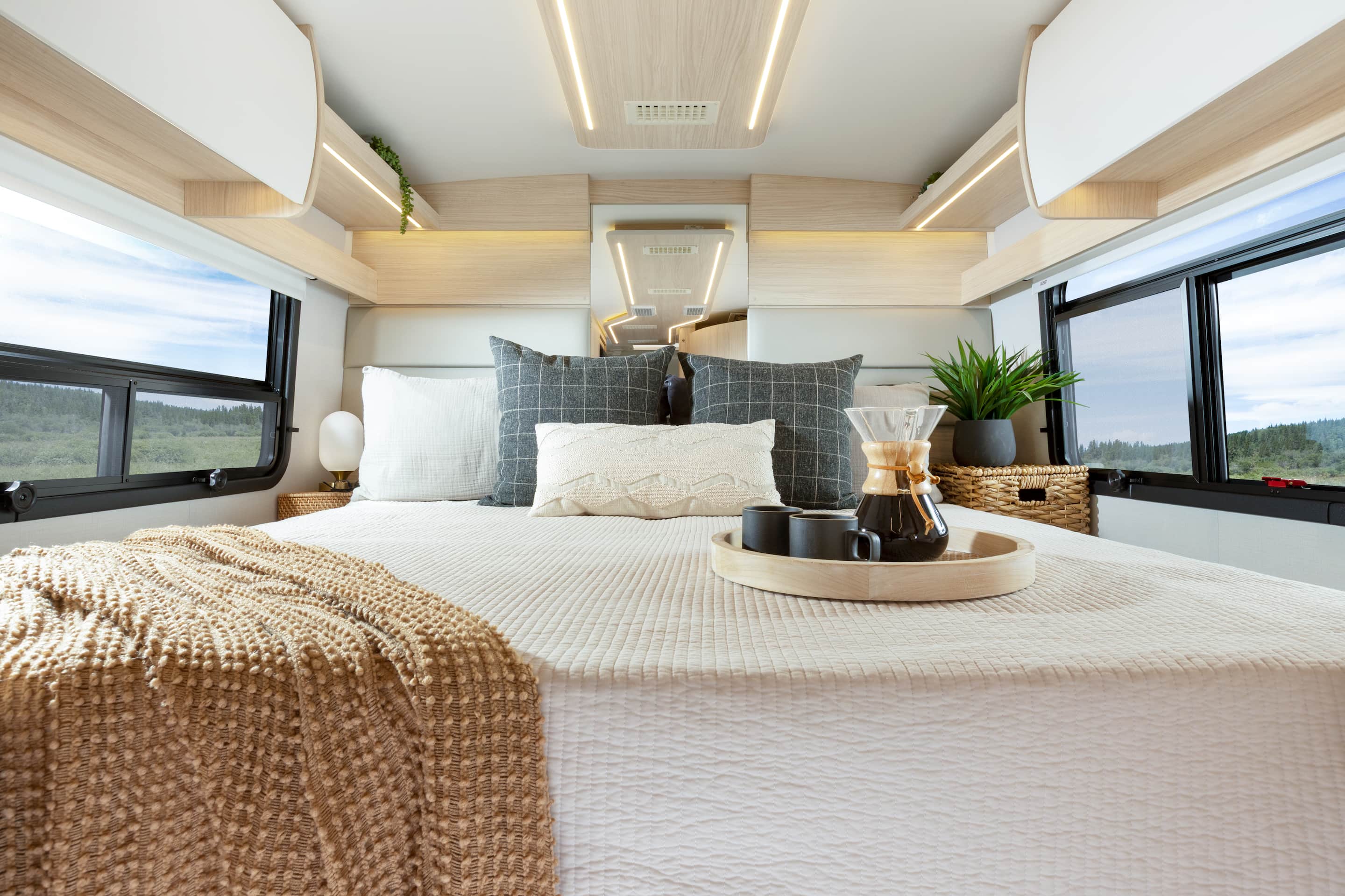 Wonder Rear Twin Bed shown with White Oak cabinetry, Crystal White cabinetry upgrade, Mineral countertops, and Sand upholstery.